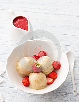 Vegan banana ice cream with strawberry sauce and fresh strawberries