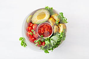 vegan buddha bowl. healthy lunch bowl with avocado, tomato, sweet corn and salsa