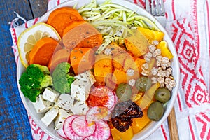 Vegan Buddha bowl - zucchini pasta, sweet potatoes, tofu with vegetables.