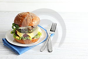 Vegan burger with beet and falafel patties served on white table.