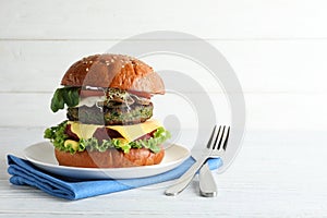 Vegan burger with beet and falafel patties served on white table.