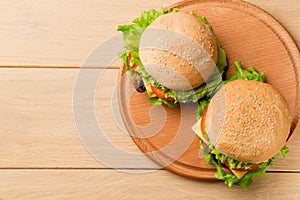 Vegan burgers with fresh vegetables on rustic wooden table, top view. Healthy fast food background with copy space