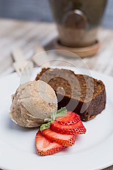 Vegan cake, vegan ice cream and strawberries on a wooden table