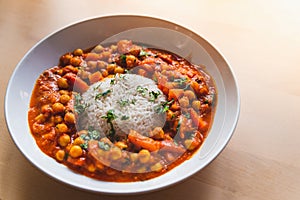 Vegan chickpeas curry. close up of fresh vegetarian indian curry known as chana masala with basmati rice and coriander leaves on