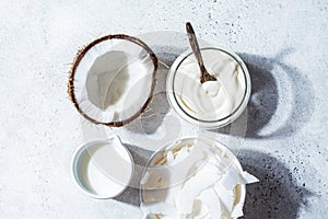 Vegan coconut products - milk, yogurt and chips, white background, top view. Coconut food concept