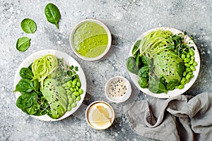 Vegan, detox Buddha bowl with avocado, spinach, micro greens, edamame beans, zucchini noodles and herb green dressing