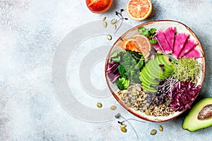 Vegan, detox Buddha bowl with quinoa, micro greens, avocado, blood orange, broccoli, watermelon radish, alfalfa seed sprouts.