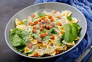 Vegan Farfalle pasta with spinach sauce with fried chickpeas.