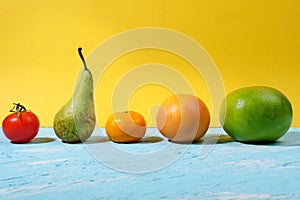 Vegan food. The concept of healthy eating. Fruits  vegetables  blue-yellow background. pear  grapefruit  tangerine  tomato  citrus
