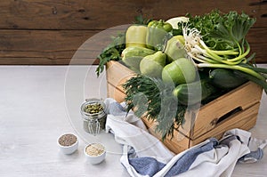 Vegan food. Fresh green hypoallergenic vegetables in wooden box and the seeds. Selective focus