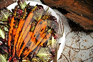 Vegan food with grilled carrots and bitter salad photo