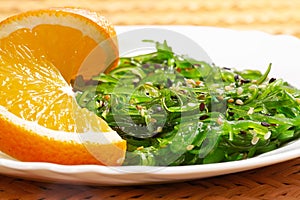 Vegan food. Japanese cuisine. Seaweed salad with orange in white plate