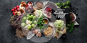 Vegan food. Pepper, broccoli, cabbage, garlic, mushrooms, pomegranate on a dark background