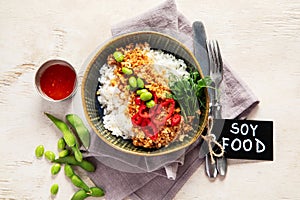 Vegan food. Soy meat, white rice, beans, red pepper on light wooden background