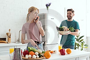 vegan girlfriend talking by smartphone while cooking