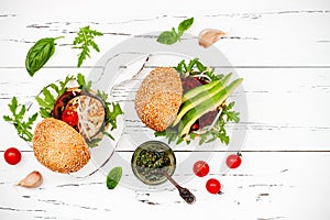 Vegan grilled eggplant, arugula, sprouts and pesto sauce burger. Veggie beet and quinoa burger with avocado. Top view, overhead