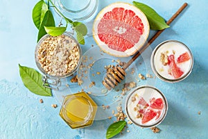 Vegan healthy breakfast. Granola with greek yogurt, honey and grapefruit in a glass. Top view flat lay background