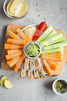 Vegan healthy snacks: guacamole, carrots, celery