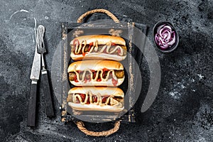 Vegan hot-dog with with assorted toppings and meatless Vegetarian sausage. Black background. Top view