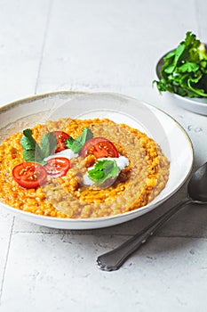 Vegan lentil soup with cilantro and tomato. Dal soup with tomatoes. Indian cuisine concept