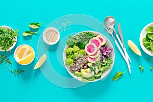 Vegan lunch bowl with quinoa, cucumber, green peas, radish, romanesco and red cabbage, avocado, spinach and arugula salad, healthy