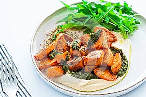 Vegan lunch - hummus, baked sweet potato and pesto, white background