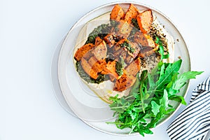 Vegan lunch - hummus, baked sweet potato and pesto, white background