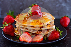 Vegan pancakes served with berries and maple syrup photo