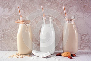 Vegan, plant based, non dairy milk in milk bottles with scattered ingredients