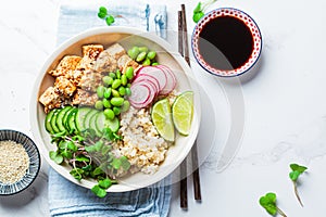 Vegan poke bowl with tofu, brown rice, beans and vegetables. Plant-based diet concept photo
