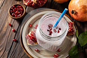 Vegan protein smoothie made from pomegranate and banana on a rustic wooden table. Healthy food, healthy lifestyle. Foodism, raw