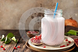 Vegan protein smoothie made from pomegranate and banana on a rustic wooden table. Healthy food, healthy lifestyle. Foodism, raw