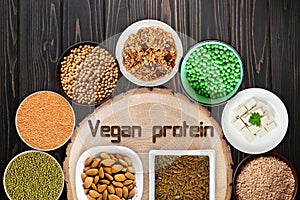 Vegan protein sources. Top view on a black wooden background.