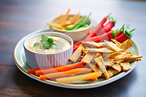 vegan queso dip with veggie sticks and gluten-free chips