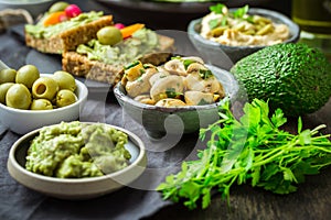 Vegan raw food snacks with fresh juicy vegetables, avocado dip, humus