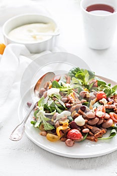 Vegan salad with tomatoes, beans and vegan sausage