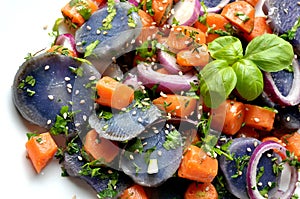 Vegan salad with violet potato, carrots and onion