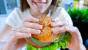 Vegan sandwich healthy vegetarian burger. Cute cheerful girl eating veggie hamburger with salad, avocado, vegetable