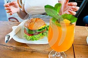 Vegan sandwich healthy vegetarian burger. Cute cheerful girl eating veggie hamburger with salad, avocado, vegetable