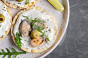 Vegan sandwich with mussels, Crisp bread, soft cheese and arugula salad. Set of tasty appetizer bruschetta. Food recipe background