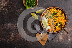 Vegan Sweet Potato Chickpea curry in wooden bowl on a dark background, top view. Healthy vegetarian food concept.