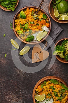 Vegan Sweet Potato Chickpea curry in wooden bowl on a dark background, top view. Healthy vegetarian food concept.