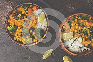 Vegan Sweet Potato Chickpea curry in wooden bowl on a dark background, top view. Healthy vegetarian food concept.