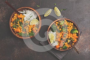 Vegan Sweet Potato Chickpea curry in wooden bowl on a dark background, top view. Healthy vegetarian food concept.