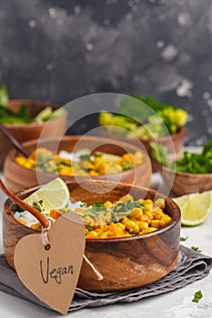 Vegan Sweet Potato Chickpea curry in wooden bowl on light background. Healthy vegetarian food concept.