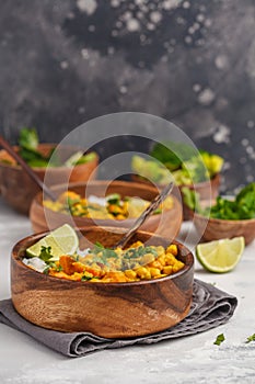 Vegan Sweet Potato Chickpea curry in wooden bowl on light background. Healthy vegetarian food concept.