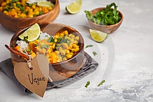 Vegan Sweet Potato Chickpea curry in wooden bowl on light background. Healthy vegetarian food concept.