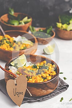 Vegan Sweet Potato Chickpea curry in wooden bowl on light background. Healthy vegetarian food concept.