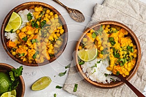 Vegan Sweet Potato Chickpea curry in wooden bowl on light background, top view, copy space. Healthy vegetarian food concept.