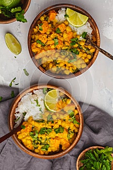 Vegan Sweet Potato Chickpea curry in wooden bowl on light background, top view, copy space. Healthy vegetarian food concept.